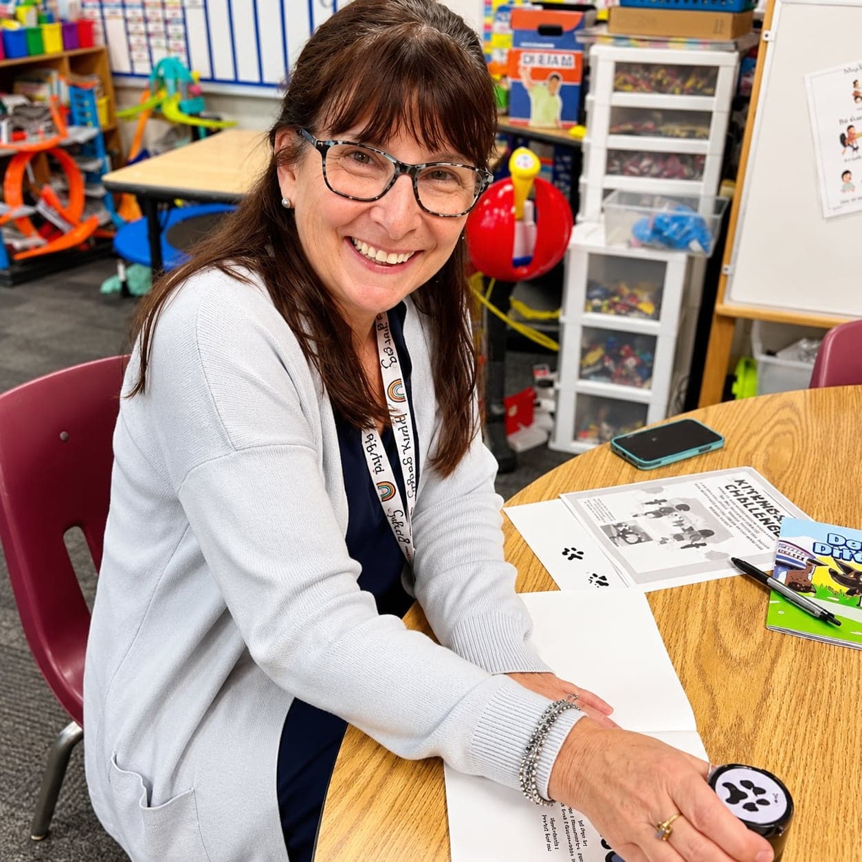 Karen at a classroom table with Daisy activity pages.